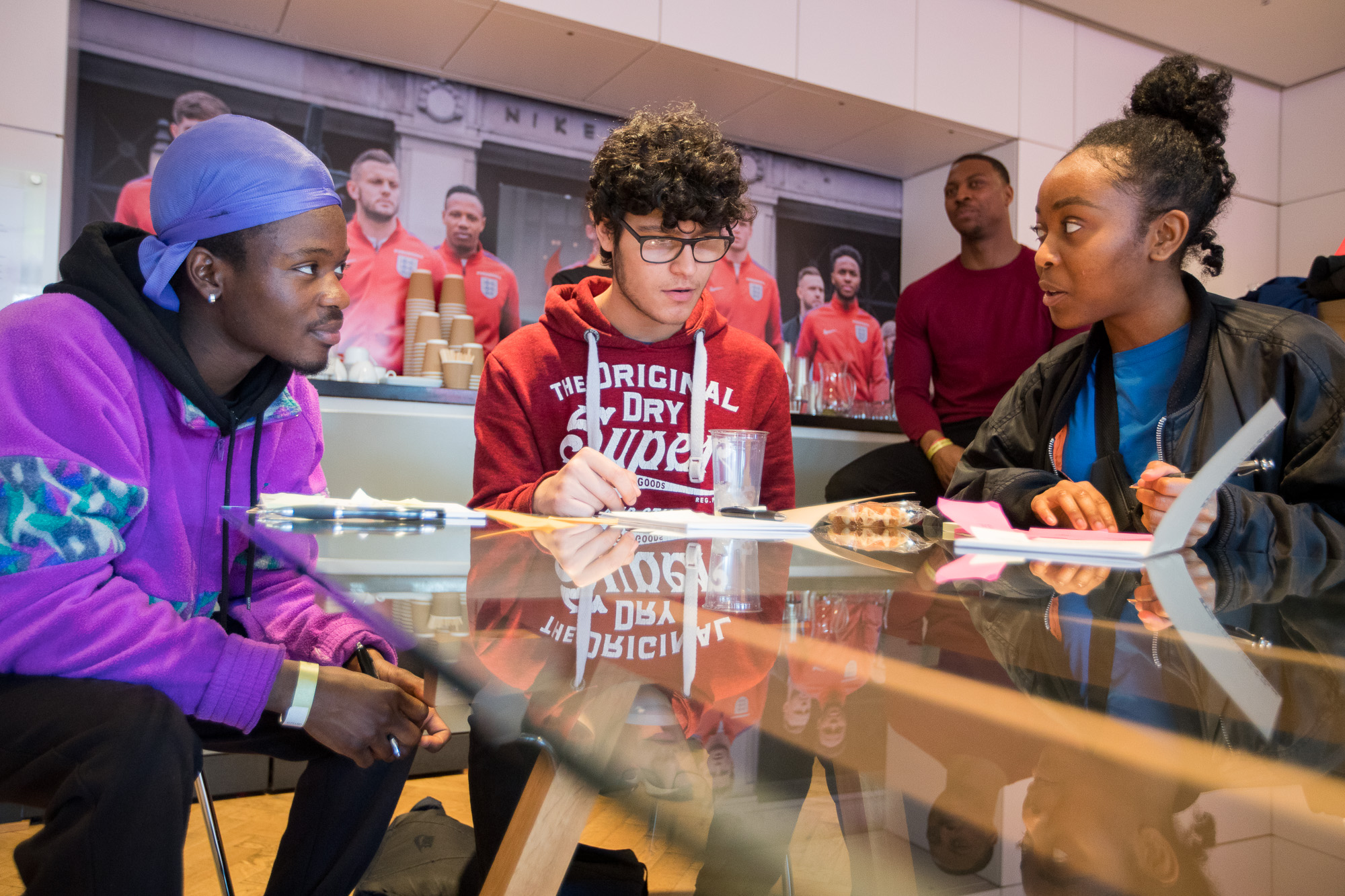 Three Students working around a glass table